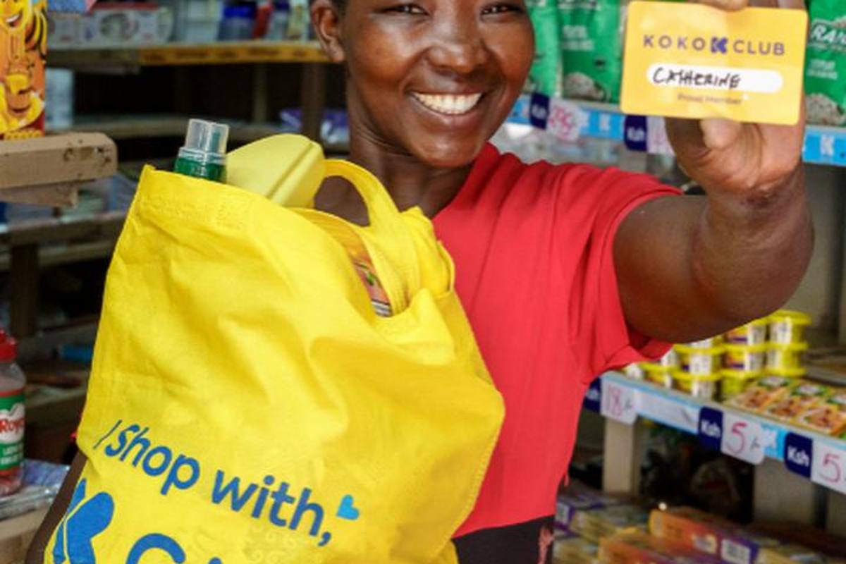A shopper holding a contactless card at a community shop